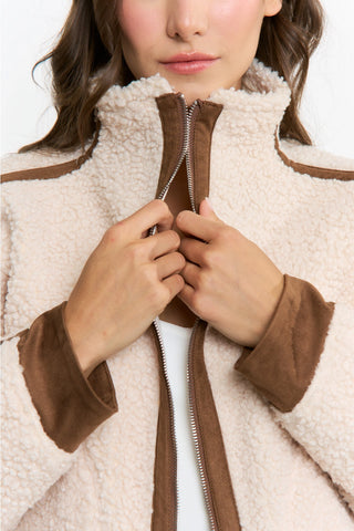 Cream sherpa zip-up jacket with brown suede trim detail, close-up view