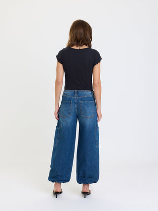 Back view of wide-leg cargo harem jeans with large patch pockets on a model