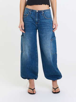 Wide-leg mid-rise cargo harem jeans with side patch pockets worn with black sandals