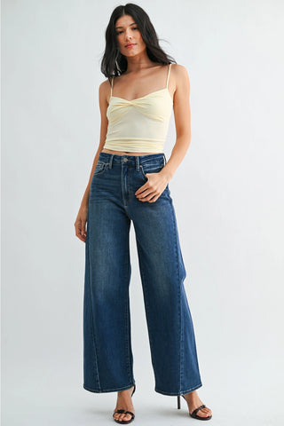 Dark wash high-rise wide-leg jeans with subtle fading and front seam detail