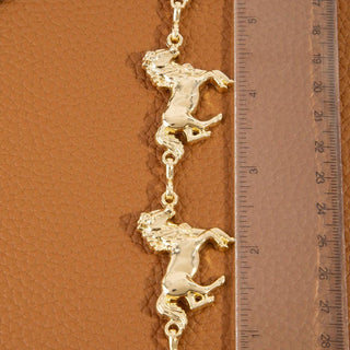 Gold-tone rearing horse charm chain belt shown against tan leather with ruler