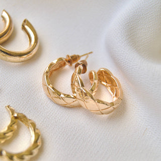 Chunky gold-tone hoop earrings with quilted diamond pattern texture, stud backing
