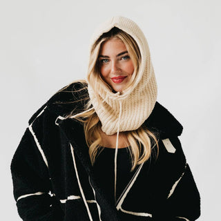 Cream knit balaclava hood scarf worn over head and neck, thick ribbed texture