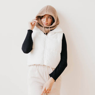Tan chunky knit balaclava hood worn over dark hair, cozy winter style