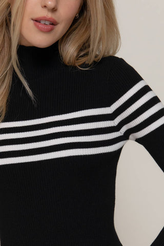 Black ribbed turtleneck sweater top with white horizontal chest stripes and long sleeves