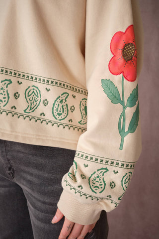 Cream sweatshirt with green paisley print and red poppy flower graphic on sleeve