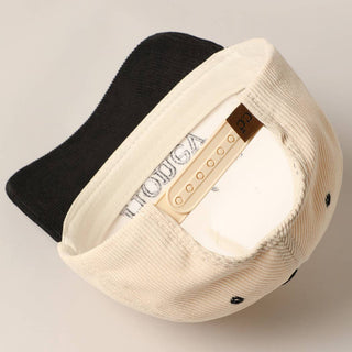Cream and black corduroy trucker caps showing interior sweatband and size adjuster