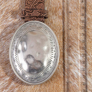 Silver hammered oval belt buckle on brown embossed vegan leather western belt
