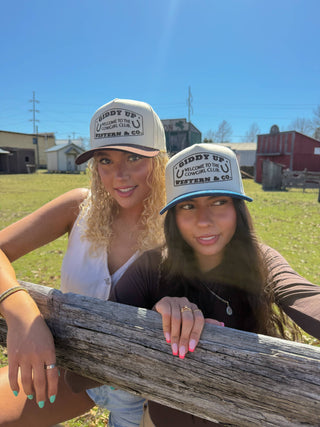 Tan embroidered Giddy Up Western Co trucker hat with brown and teal brim variants