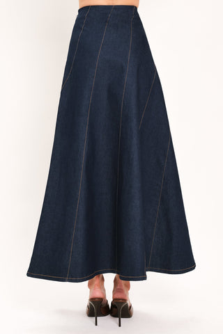 Back view of a dark denim maxi skirt with diagonal seams and flared silhouette