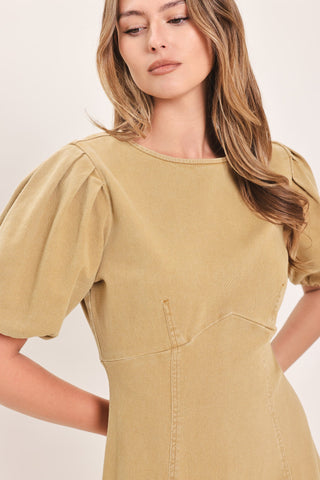Close-up detail of woven midi dress with round neckline, short puff sleeves, and seam detailing