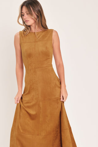 Woman wearing a sleeveless faux suede midi dress with round neckline and flared circle skirt