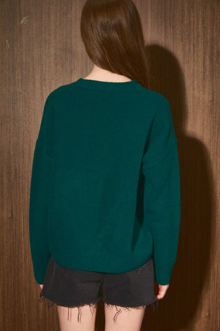 Oversized hunter green knit sweater shown from the back with long sleeves