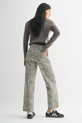 Model wearing wide-leg high-rise straight pants in black and white zebra print, back view