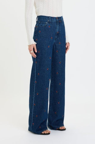 High rise wide leg jeans with allover cherry embroidery on dark indigo denim, styled with white top