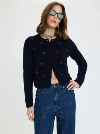 Model wearing navy cropped cardigan with red cherry embroidery, paired with matching cherry jeans