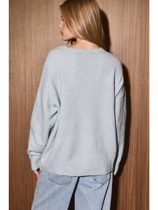 Back view of oversized crew neck knit sweater with dropped shoulders and ribbed hem