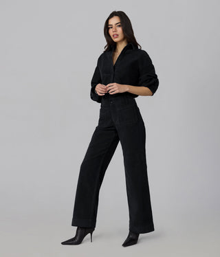 Model wearing high rise wide leg corduroy pants with matching black button-down shirt and heeled boots