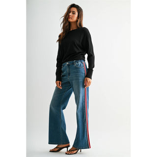 Model wearing high-rise wide leg jeans with red and white side stripe detail and black top