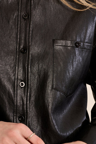 Close-up detail of black faux leather button-front overshirt with chest pocket