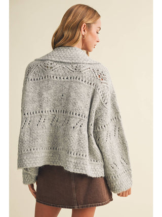 Back view of oversized eyelit knit sweater with open-work pattern and wide collar