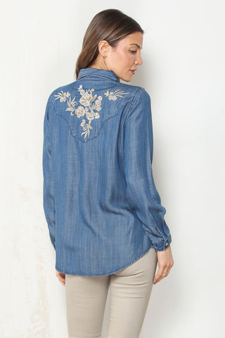 Back view of the Prescott Embroidered Denim Shirt, showing ivory floral embroidery across the back yoke of the medium-wash denim shirt