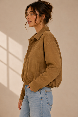 Woman wearing a cropped camel suede bubble jacket with collar and elasticated hem, side view