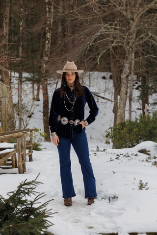 Navy blue velvet button-up shirt styled with flare jeans and concho belt