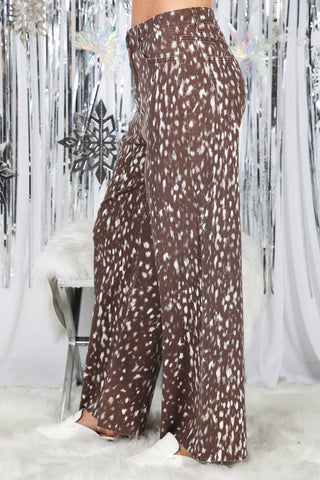 Wide-leg brown animal print pants with white spots, shown from side angle on model