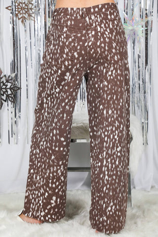 Back view of wide-leg pants with white spotted animal print on brown fabric